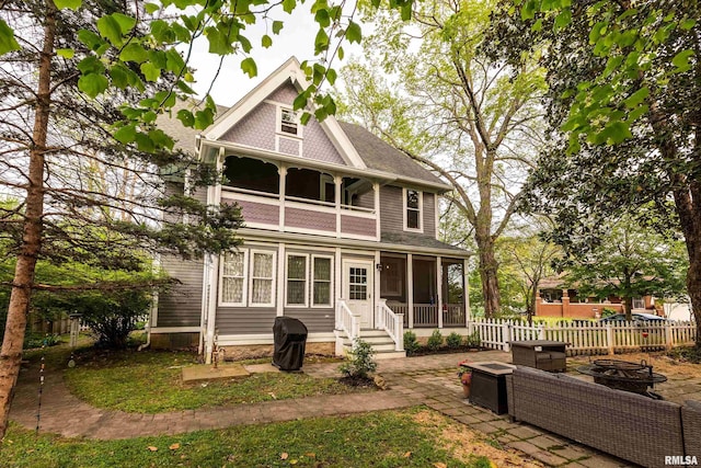 301 W High St, Anna, IL 62906 - back of house with a fire pit, a balcony, a sunroom, fence, and a shingled roof