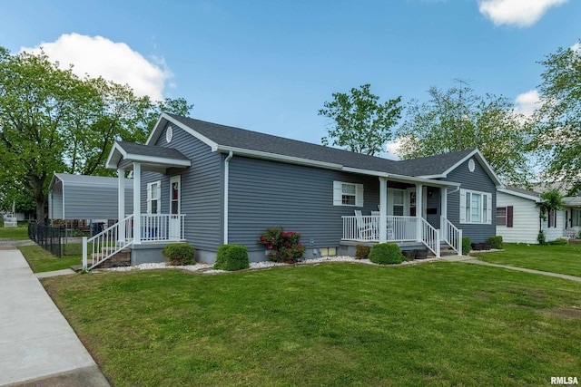 view of front of house with covered porch, a front lawn, and roof with shingles