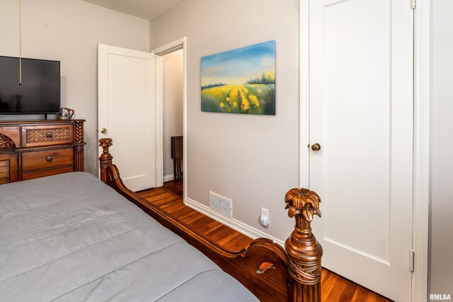 bedroom featuring wood finished floors and baseboards