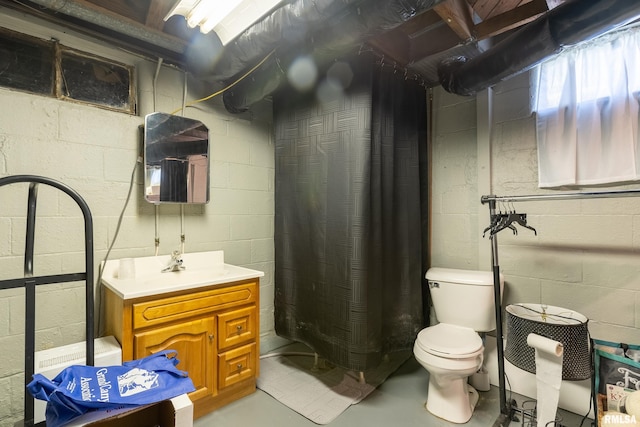 bathroom with toilet, finished concrete flooring, vanity, and curtained shower