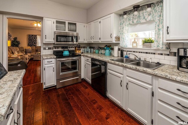 kitchen featuring stainless steel appliances, a sink, dark wood-type flooring, and white cabinetry