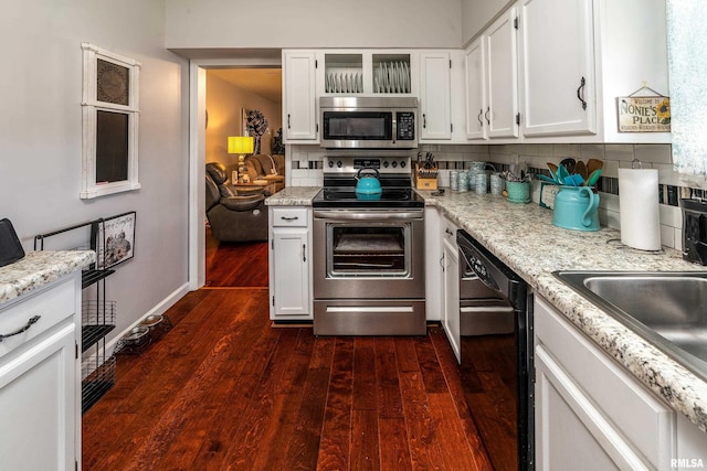 kitchen featuring stainless steel appliances, dark wood-type flooring, decorative backsplash, and white cabinetry
