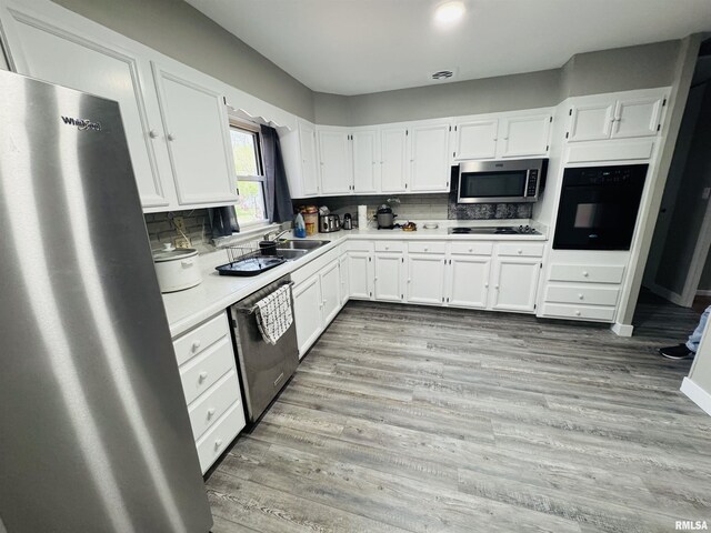 kitchen featuring black appliances, white cabinetry, light countertops, and decorative backsplash