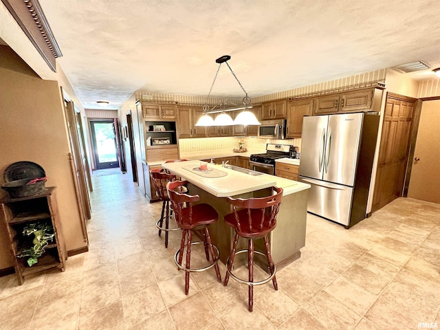 7 Lakewood Dr, Centralia, IL 62801 - kitchen featuring stainless steel appliances, light countertops, a sink, a center island with sink, and hanging light fixtures