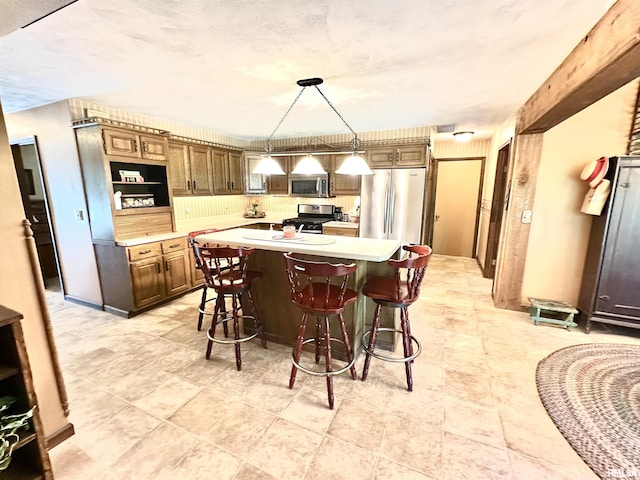 7 Lakewood Dr, Centralia, IL 62801 - kitchen featuring appliances with stainless steel finishes, light countertops, a kitchen breakfast bar, a center island, and decorative light fixtures