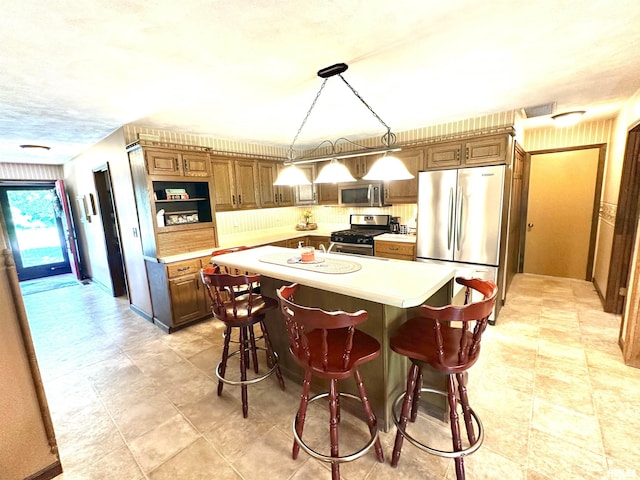 7 Lakewood Dr, Centralia, IL 62801 - kitchen featuring appliances with stainless steel finishes, light countertops, a center island, a breakfast bar, and decorative light fixtures