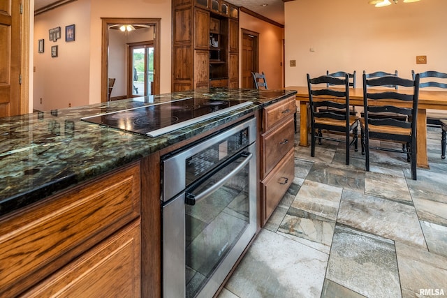 500 Swink Ln, Jonesboro, IL 62952 - kitchen featuring stainless steel oven, black electric cooktop, light stone finish floors, brown cabinets, and ornamental molding