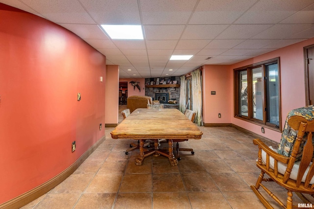 500 Swink Ln, Jonesboro, IL 62952 - tiled dining room featuring a stone fireplace, baseboards, and a drop ceiling
