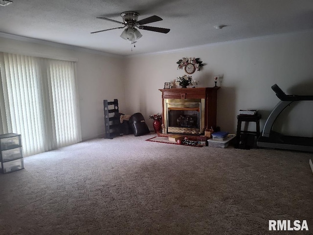 carpeted living room featuring a fireplace with raised hearth, a ceiling fan, and crown molding