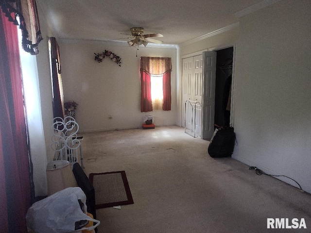 carpeted spare room with crown molding and a ceiling fan