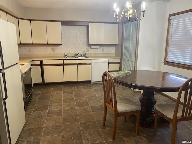 11729 Kevin Ln, Carterville, IL 62918 - kitchen with white appliances, a sink, light countertops, a chandelier, and pendant lighting