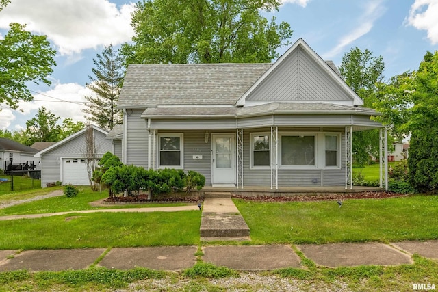 1104 Barham Ave, Johnston City, IL 62951 - view of front facade featuring a porch, a front yard, a shingled roof, and an outdoor structure