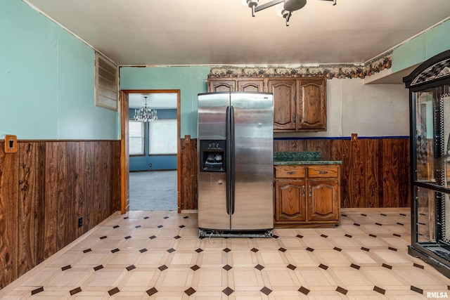 1104 Barham Ave, Johnston City, IL 62951 - kitchen featuring stainless steel fridge with ice dispenser, wooden walls, wainscoting, light floors, and a chandelier