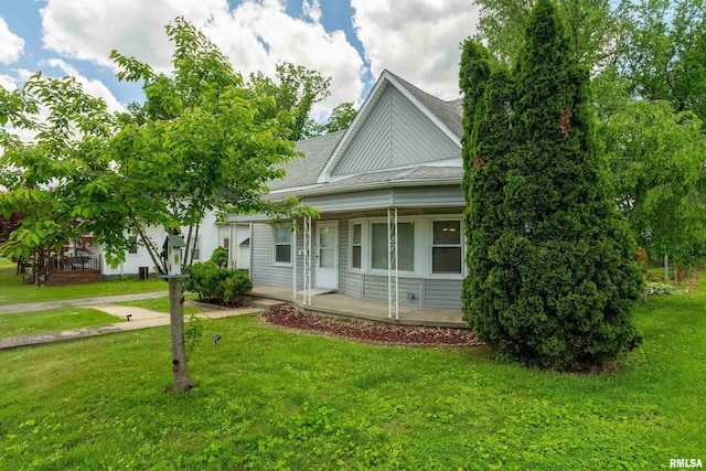 1104 Barham Ave, Johnston City, IL 62951 - view of front facade featuring covered porch, roof with shingles, and a front lawn