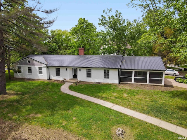 802 W Main St, Vienna, IL 62995 - ranch-style house featuring a sunroom, metal roof, a chimney, a front lawn, and stucco siding