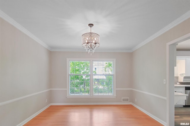 802 W Main St, Vienna, IL 62995 - spare room with a chandelier, light wood-style flooring, crown molding, and baseboards