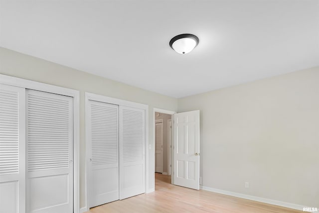802 W Main St, Vienna, IL 62995 - unfurnished bedroom with light wood-type flooring, two closets, and baseboards