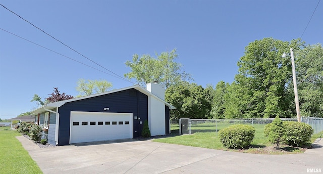view of home's exterior with a chimney, a garage, and driveway