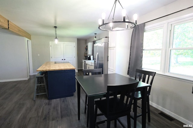 dining room featuring baseboards, dark wood-type flooring, and a chandelier
