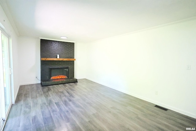 unfurnished living room featuring a fireplace, wood finished floors, ornamental molding, and baseboards