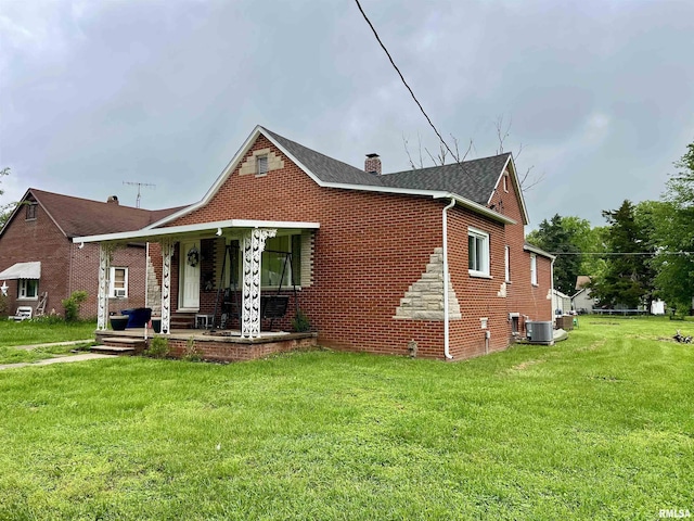 405 E Saint Louis St, West Frankfort, IL 62896 - bungalow with a porch, a front yard, a chimney, brick siding, and central AC unit