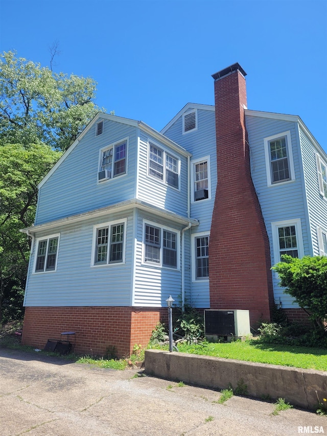 1806 Pace Ave, Mount Vernon, IL 62864 - view of home's exterior with brick siding, a chimney, and central AC unit
