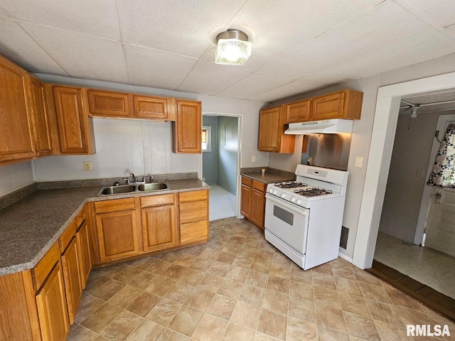 2307 Perkins Ave Unit A, Mount Vernon, IL 62864 - kitchen with white range with gas cooktop, a sink, under cabinet range hood, and brown cabinets