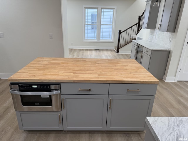 920 E 3rd St, Centralia, IL 62801 - kitchen featuring gray cabinetry, butcher block countertops, baseboards, and light wood finished floors