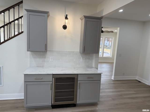 920 E 3rd St, Centralia, IL 62801 - kitchen with gray cabinets, wine cooler, backsplash, wood finished floors, and recessed lighting