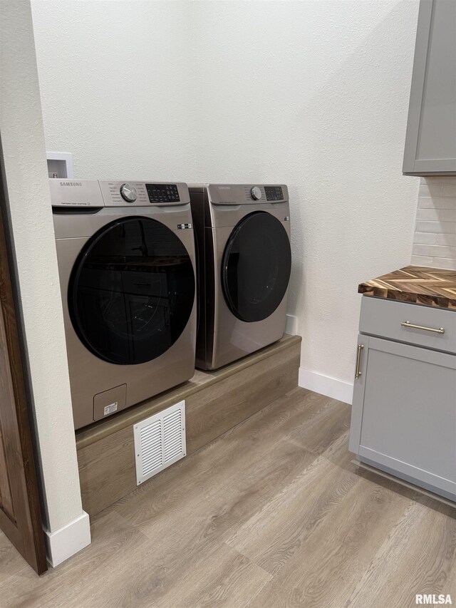 920 E 3rd St, Centralia, IL 62801 - laundry room featuring washer and clothes dryer, baseboards, light wood finished floors, and cabinet space
