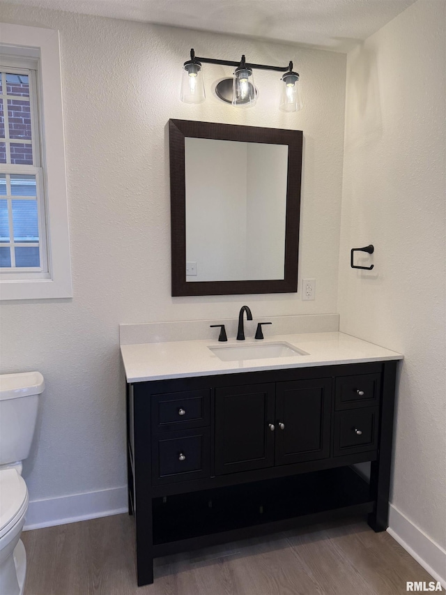920 E 3rd St, Centralia, IL 62801 - half bath with wood finished floors, toilet, baseboards, and vanity