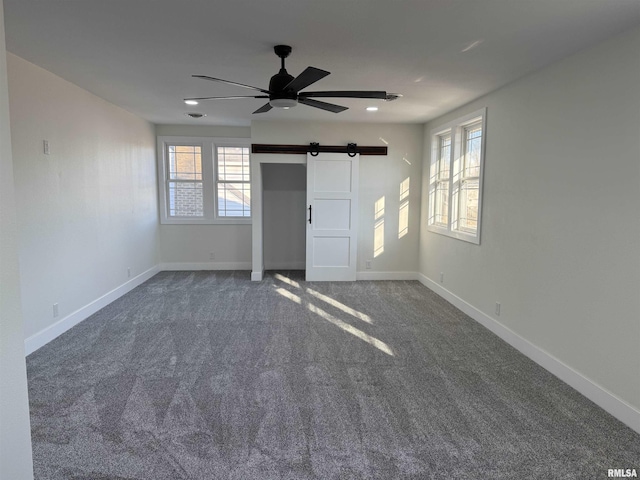 920 E 3rd St, Centralia, IL 62801 - unfurnished bedroom with a barn door, carpet floors, multiple windows, baseboards, and recessed lighting
