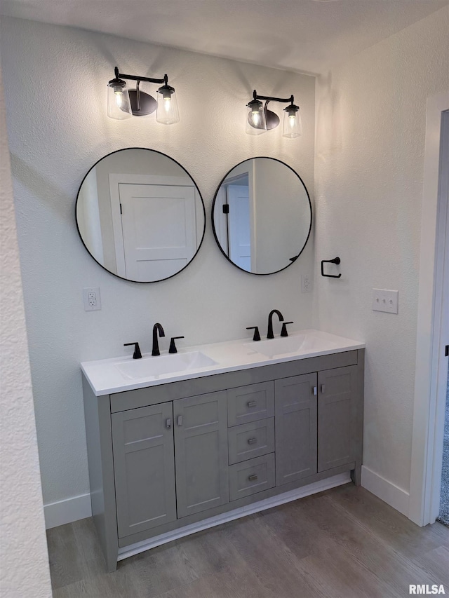 920 E 3rd St, Centralia, IL 62801 - bathroom with wood finished floors, baseboards, and double vanity
