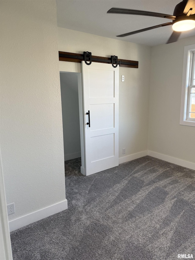 920 E 3rd St, Centralia, IL 62801 - unfurnished room with ceiling fan, dark carpet, a barn door, and baseboards