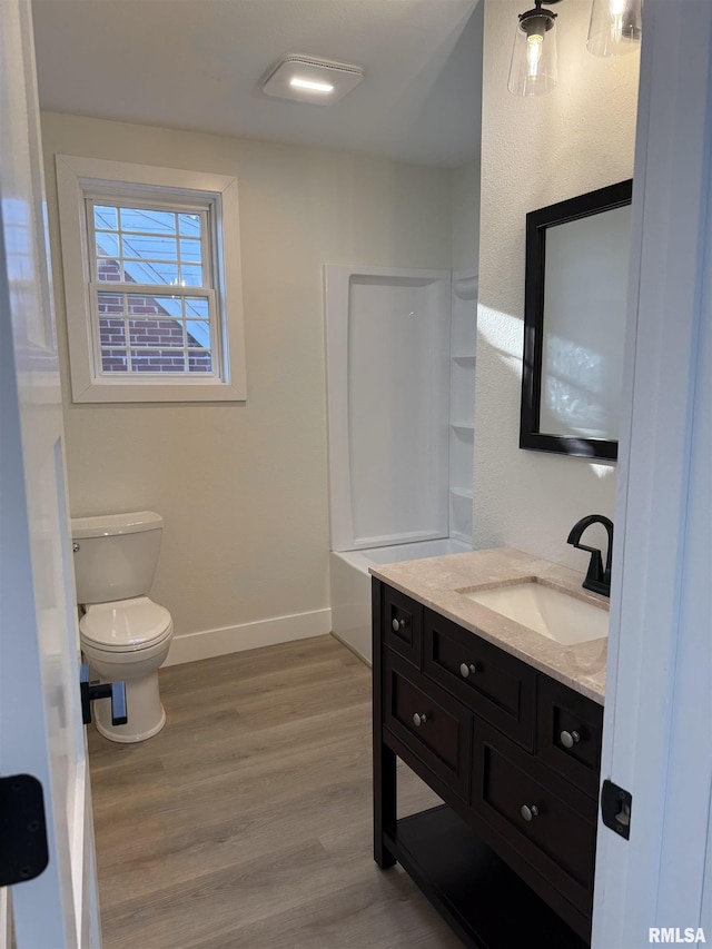920 E 3rd St, Centralia, IL 62801 - full bath with wood finished floors, vanity, toilet, and baseboards