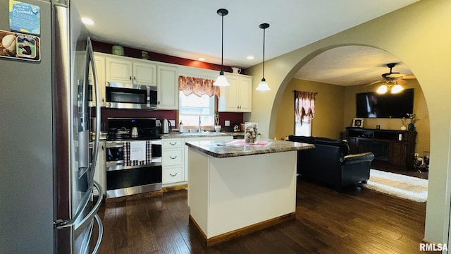 105 E Yung St, Sesser, IL 62884 - kitchen with appliances with stainless steel finishes, arched walkways, open floor plan, dark wood-style flooring, and white cabinets
