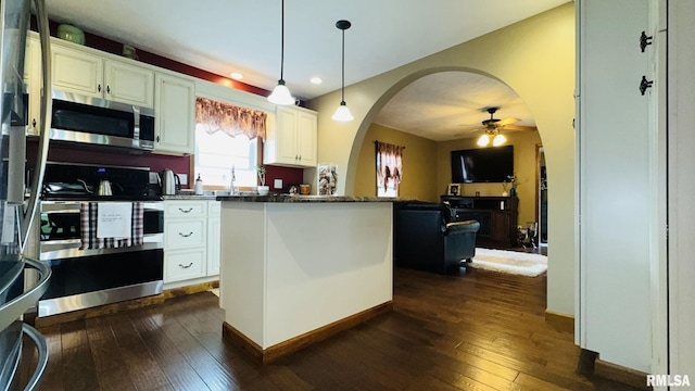 105 E Yung St, Sesser, IL 62884 - kitchen featuring appliances with stainless steel finishes, arched walkways, dark wood finished floors, a ceiling fan, and white cabinets