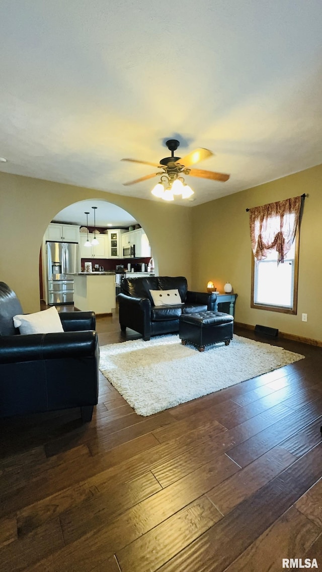 105 E Yung St, Sesser, IL 62884 - living room with arched walkways, ceiling fan, and dark wood-style floors