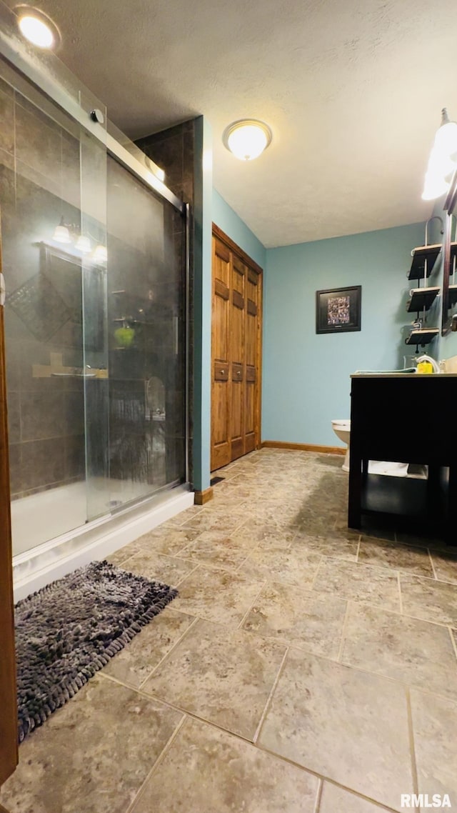 105 E Yung St, Sesser, IL 62884 - bathroom featuring a stall shower, baseboards, stone tile floors, vanity, and toilet