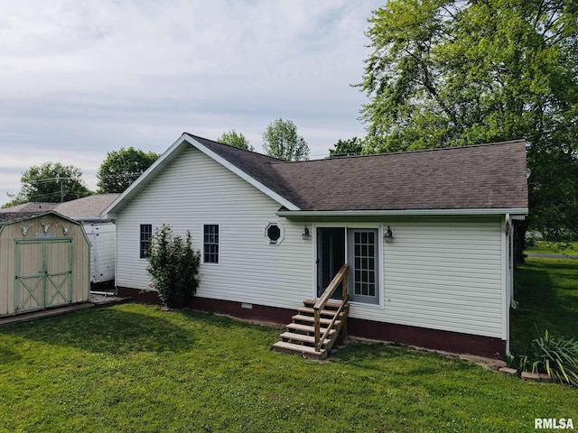 105 E Yung St, Sesser, IL 62884 - rear view of house with entry steps, a storage unit, an outdoor structure, a yard, and a shingled roof