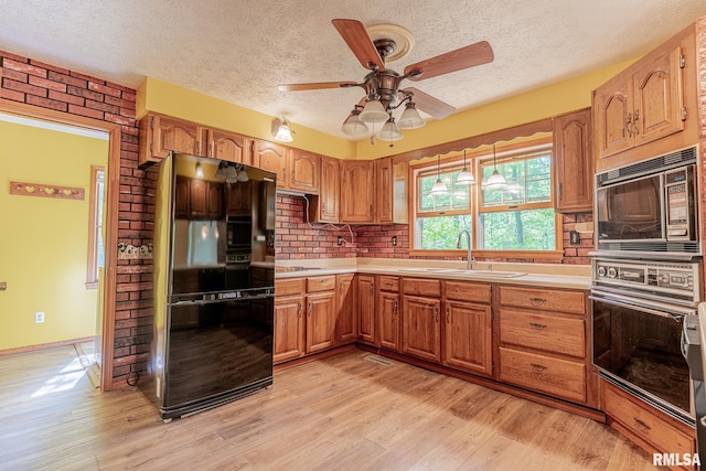 15751 E Tolle Rd, Mount Vernon, IL 62864 - kitchen with black appliances, a sink, light wood-style flooring, light countertops, and a textured ceiling