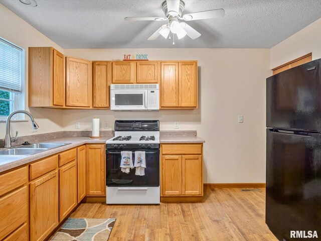 2234 Cascade Ln, Centralia, IL 62801 - kitchen featuring freestanding refrigerator, white microwave, gas stove, a sink, and a textured ceiling