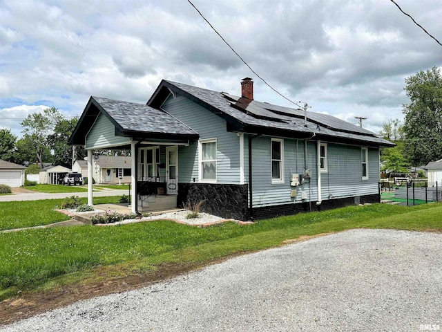 401 S 1st St, Marion, IL 62959 - view of side of property with a porch, roof mounted solar panels, a chimney, and a shingled roof