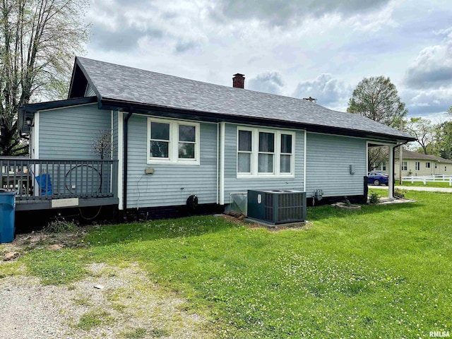 401 S 1st St, Marion, IL 62959 - rear view of house featuring central air condition unit, a chimney, a yard, and roof with shingles