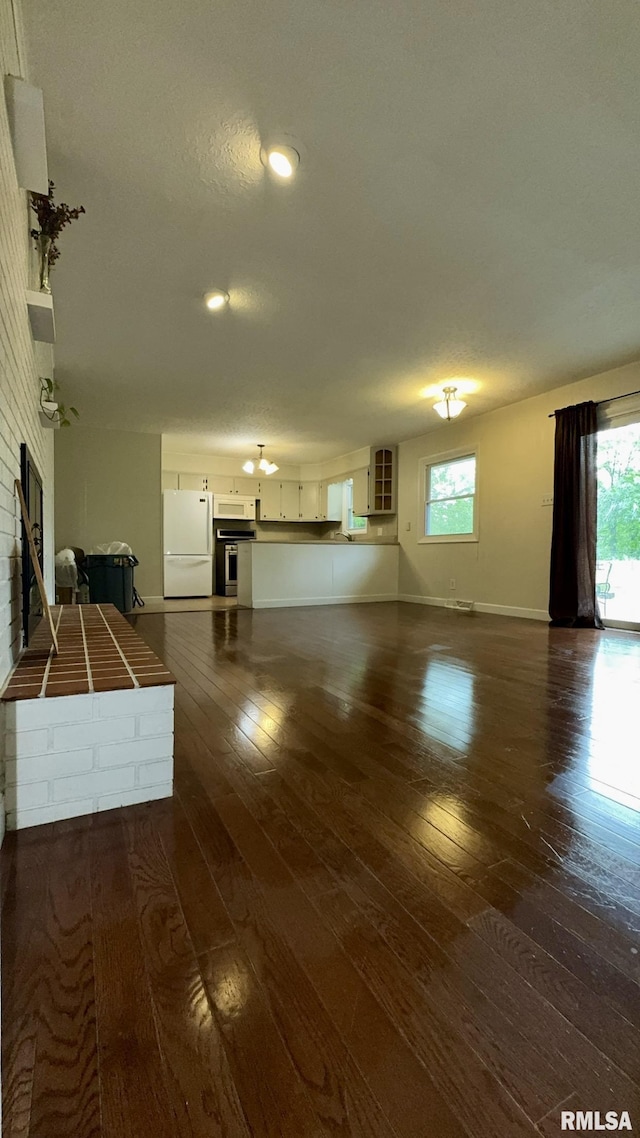 112 Prairie Rd, Carterville, IL 62918 - unfurnished living room featuring a fireplace, dark wood-style flooring, healthy amount of natural light, and baseboards