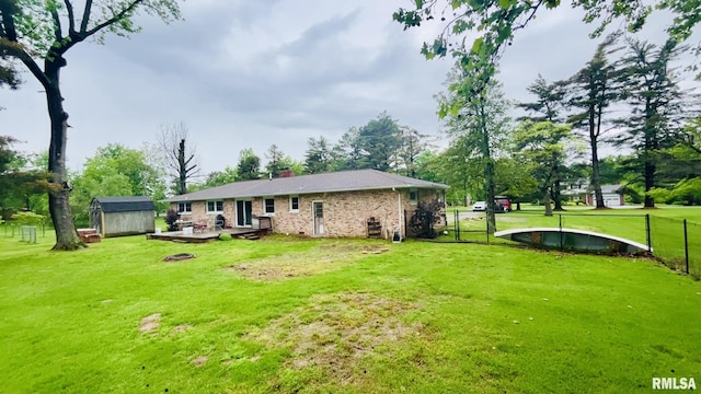 112 Prairie Rd, Carterville, IL 62918 - rear view of property with a shed, an outdoor structure, a chimney, brick siding, and a fire pit