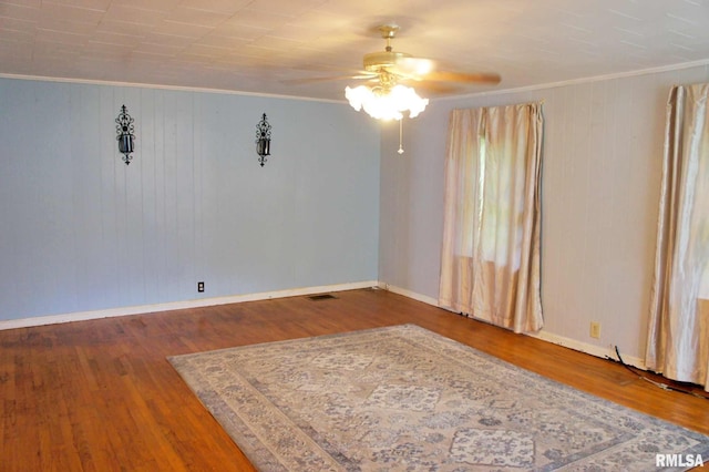 207 Butler St, Metropolis, IL 62960 - unfurnished room featuring ceiling fan, ornamental molding, baseboards, wood finished floors, and wood walls