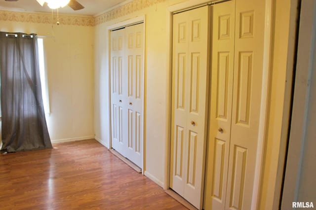 207 Butler St, Metropolis, IL 62960 - unfurnished bedroom featuring two closets, wood finished floors, baseboards, and ornamental molding