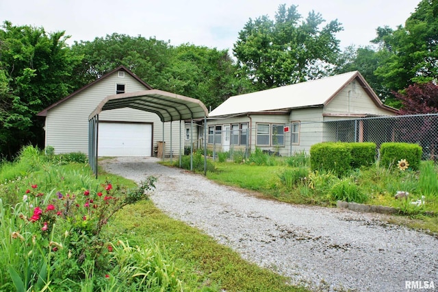 207 Butler St, Metropolis, IL 62960 - view of front of property featuring fence, gravel driveway, a carport, and a detached garage