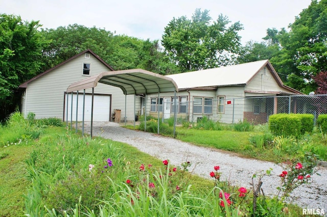 207 Butler St, Metropolis, IL 62960 - view of front facade featuring fence, gravel driveway, a detached carport, and a garage